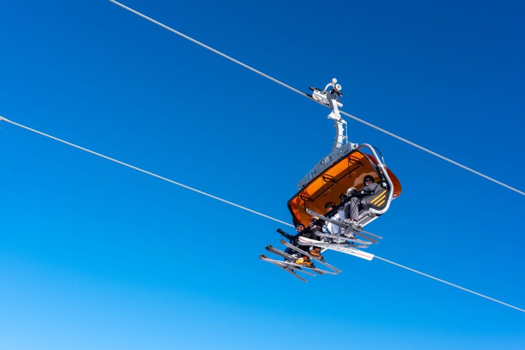 Ski lift carrying skiers against a clear blue sky in Białka Tatrzańska, Poland.